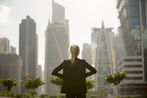 A businesswoman considers property management companies while viewing the skyline