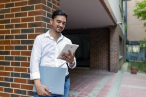 property manager with tablet and binder in front of apartment building